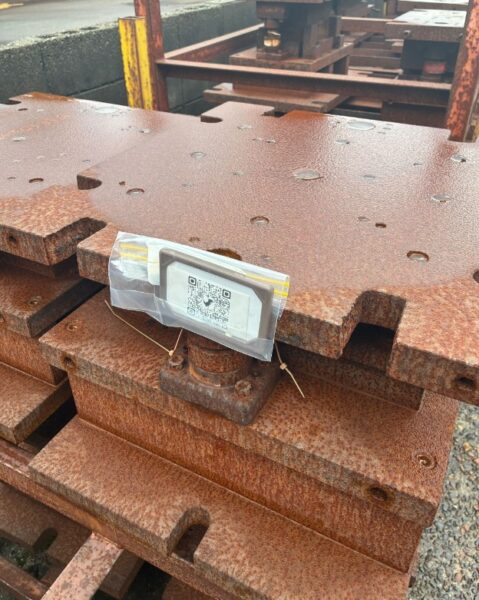 屋外保管されてる金型にチップロックにいれたQRコードを付けてる様子